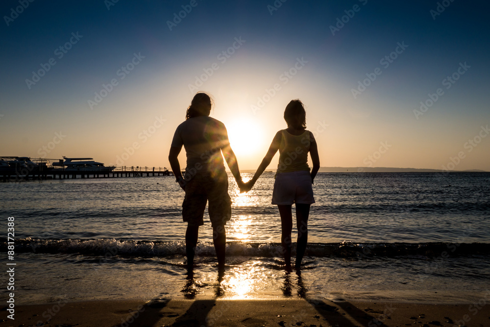 Couple holding hand at ocean sunset sunrise