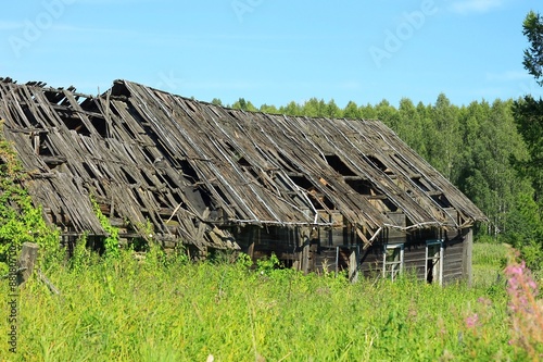 Заброшенный деревенский дом в поле photo