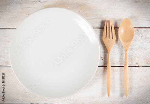 plate with fork and spoon on wood ,with shadows
