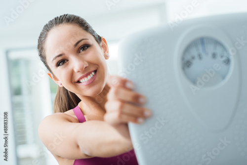 Happy woman showing a scale Free Download Happy woman showing a scale - GFXLoad