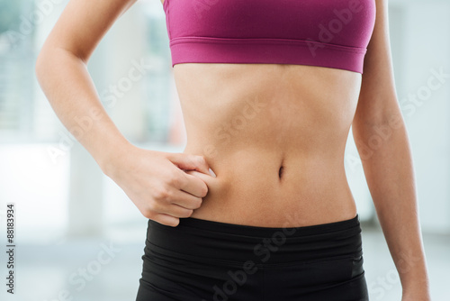 Woman pinching fat on her belly