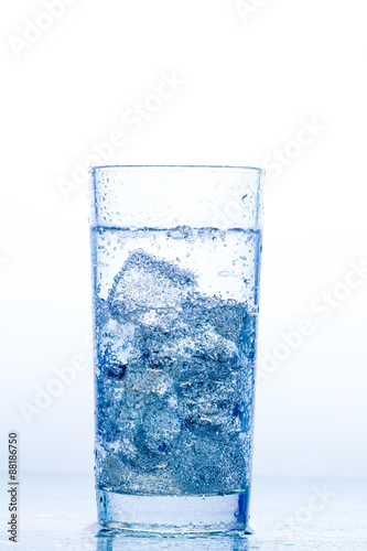 elegant glass with water and ice on a white background