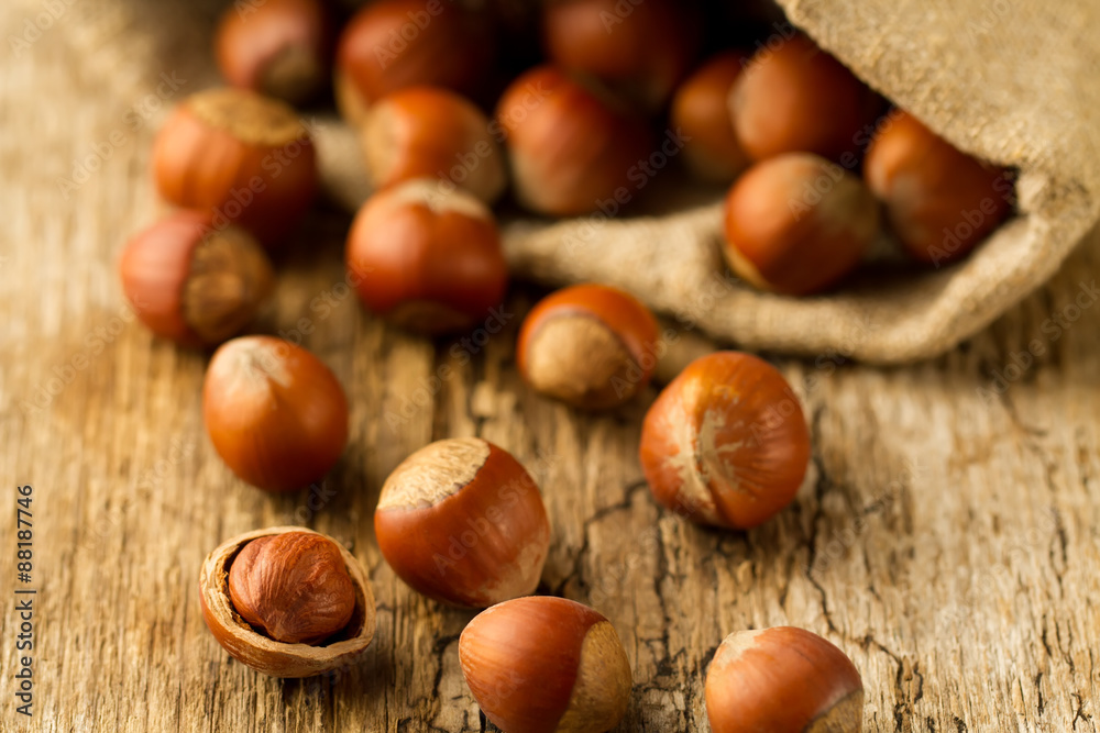 hazelnuts scattered out of the bag on old wooden background. Healthy vegetarian food hazelnuts scattered out of the bag on old wooden background. Healthy vegetarian food