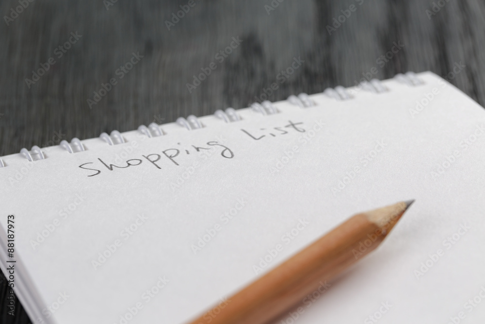 closeup photo of open empty notepad with shopping list phrase closeup photo of open empty notepad with shopping list phrase
