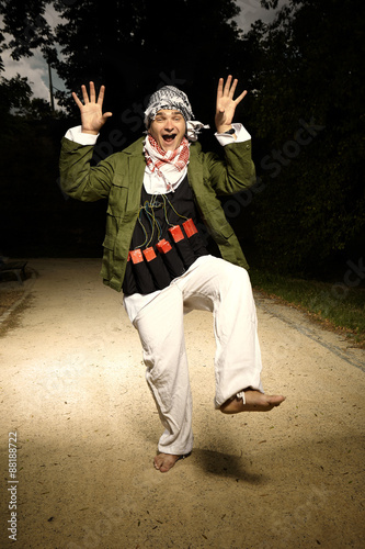 Portrait of man with vest of plastic explosives dancing in park