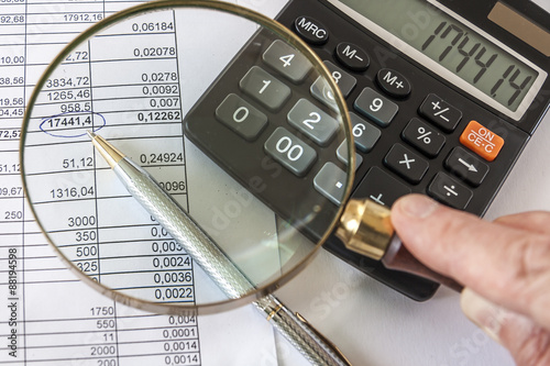 Hand Holding Magnifying Glass To Checking Finansical Document