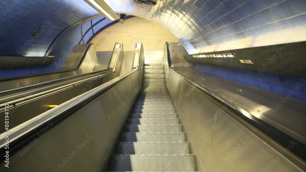 Escalator going down to enter subway station Escalator going down to enter subway station