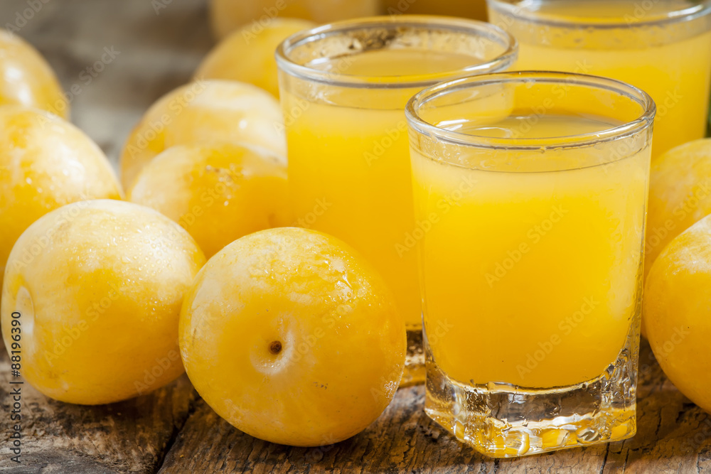 Delicious fresh juice of yellow sweet plums in a glass on the ol Delicious fresh juice of yellow sweet plums in a glass on the ol