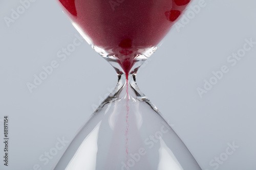 Red sand in an hourglass, horizontal