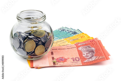 Saving concept. Banknotes and coins with a glass container isolated on white background.