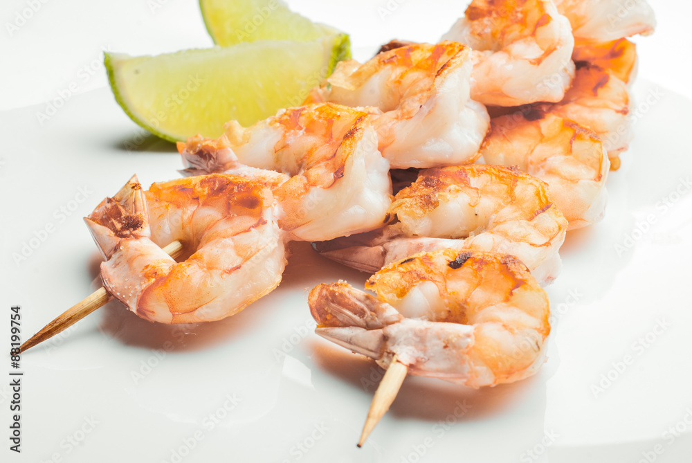 grilled shrimps with slices of lime on white dish grilled shrimps with slices of lime on white dish