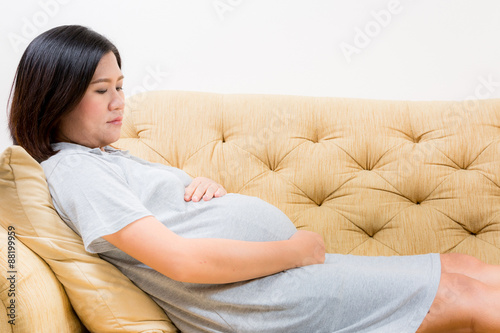 Pregnant woman relaxing at home on sofa