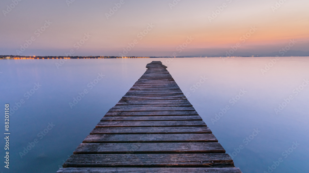 Fototapeta Długi Drewniany Nabrzeże na Garda jeziorze przy zmierzchem
