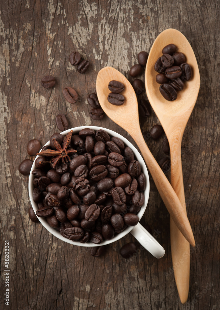 Fototapeta premium Coffee beans in cup on wood background,selective focus