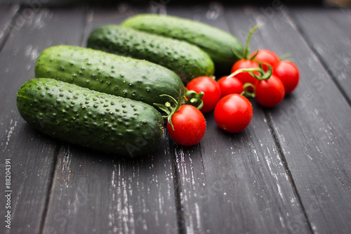 delicious fresh cucumbers and cherry tomatoes lie on a wooden table. Correct and healthy food