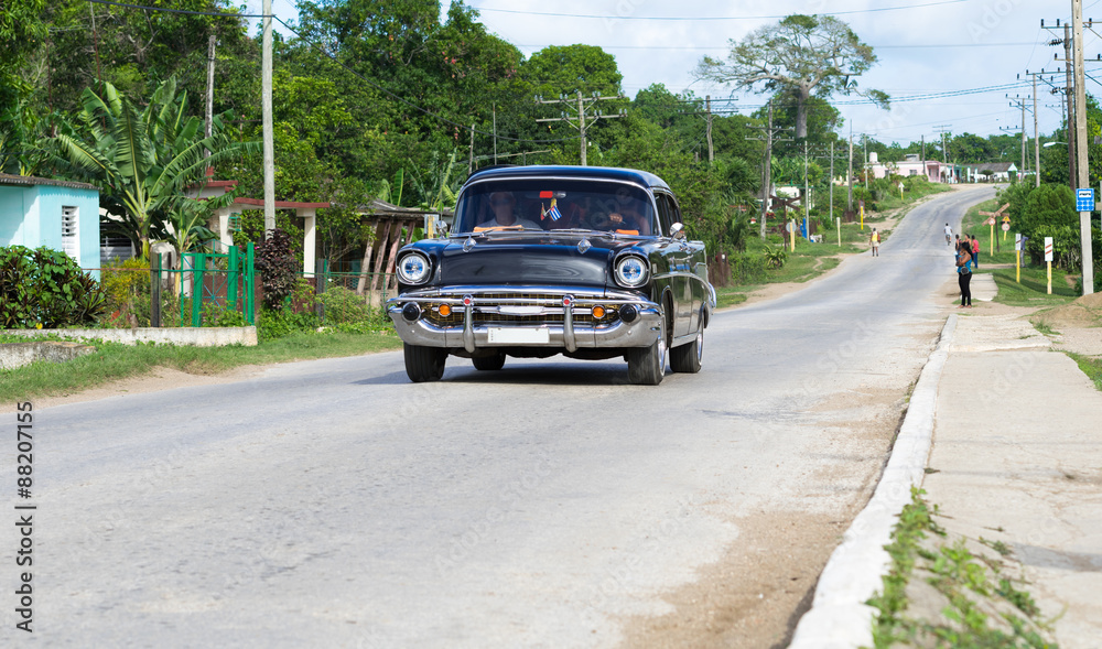 Kuba schwarzer amerikanischer Oldtimer fährt auf der Landstrasse im Landesinneren