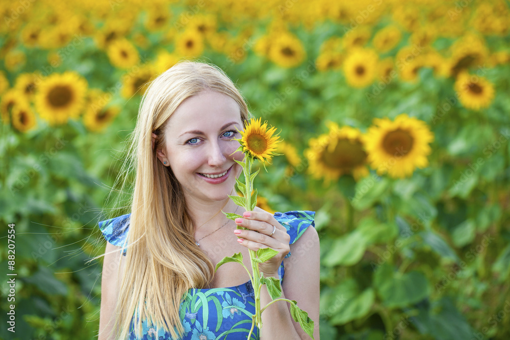 Portrait of a beautiful young blonde woman in blue dress on a ba Portrait of a beautiful young blonde woman in blue dress on a ba