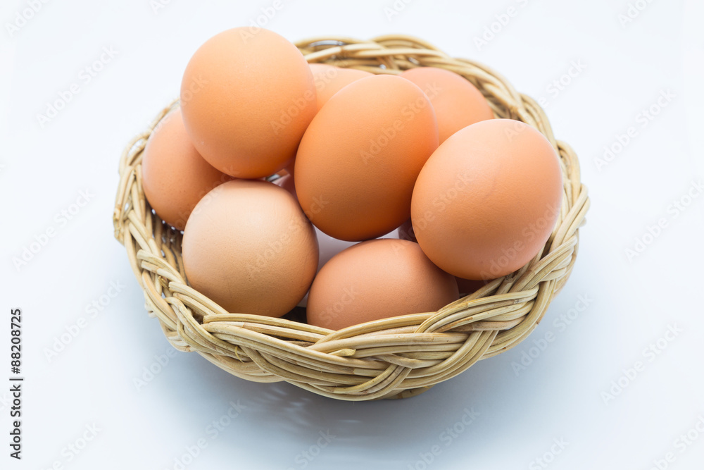 Chicken eggs in a basket on white Chicken eggs in a basket on white