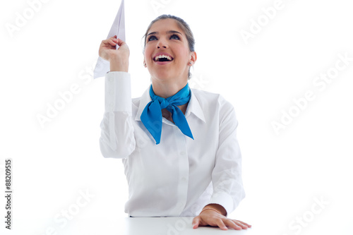 Beautiful hostess holding paper airplane. Isolated on white. photo