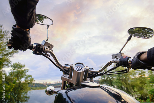 Biker on a motorcycle on sunset. First person view