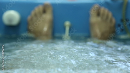 Man lies in the treatment bath in a spa, bath with oxygen and herbs
