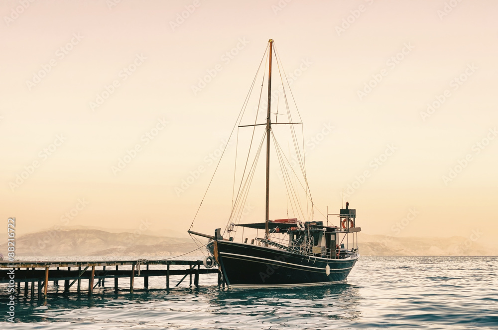 old sailing boat in the harbor at sunset