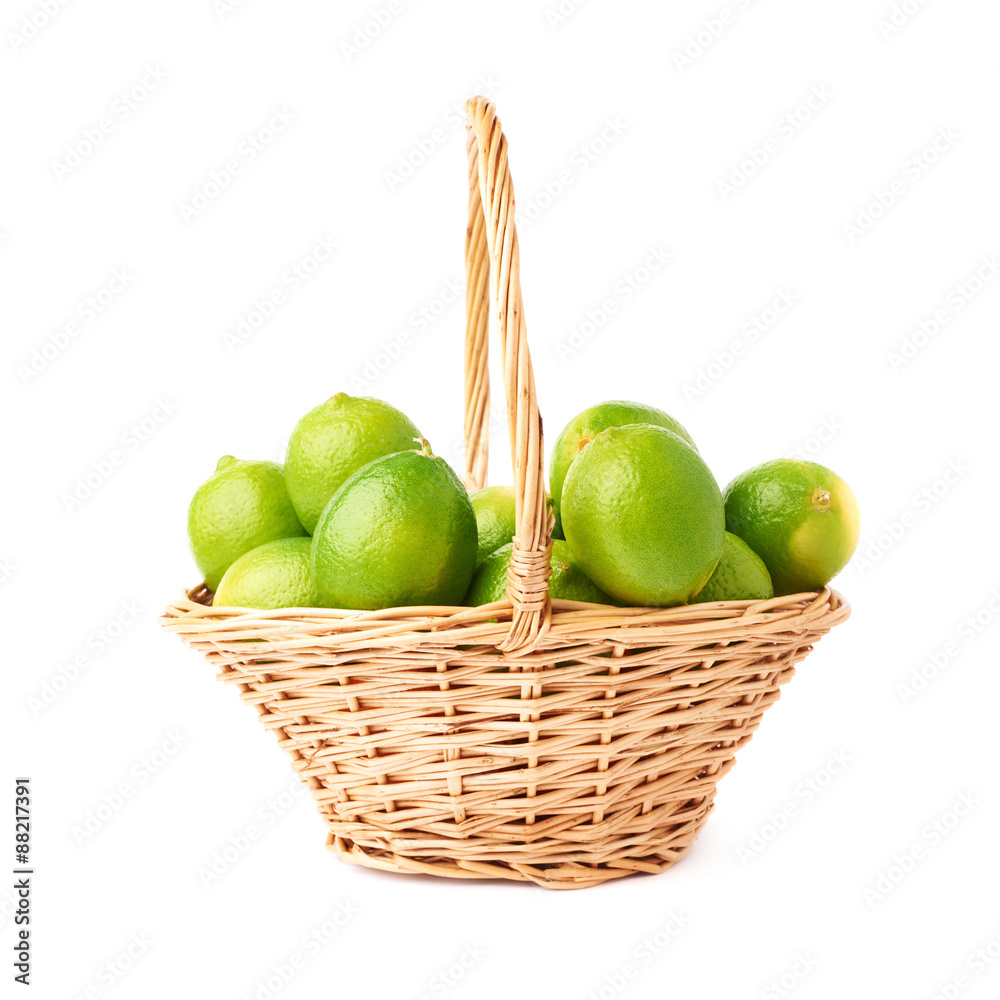 Wicker basket full of multiple ripe limes, composition isolated Wicker basket full of multiple ripe limes, composition isolated