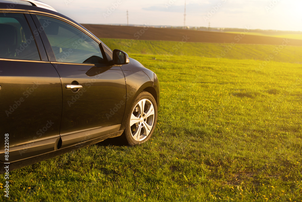 The unknown vehicle car on the grass in field at summer sunset The unknown vehicle car on the grass in field at summer sunset