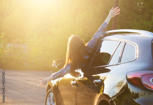 Fotografie Female driver in car raising arms and feeling the freedom of dri