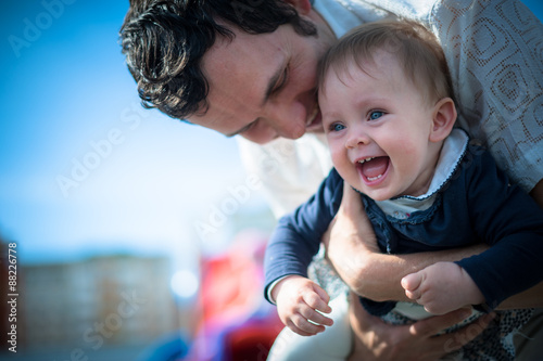 Image of cute little daughter in young dad's hands