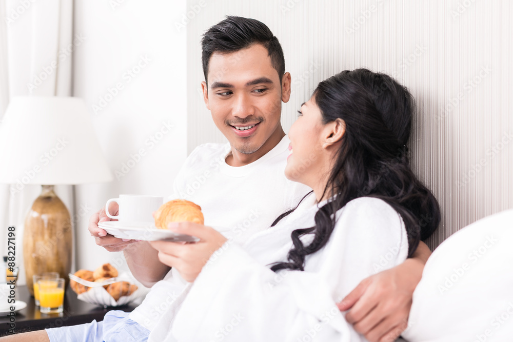Asian couple lounging in bed at morning Asian couple lounging in bed at morning