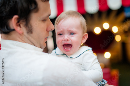 Image of young dad with cute little daughter in his arms