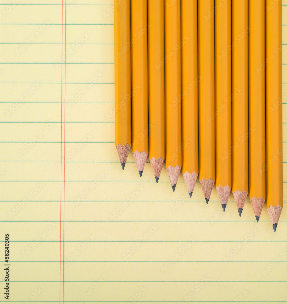 Row of yellow pencils against notepad Row of yellow pencils against notepad
