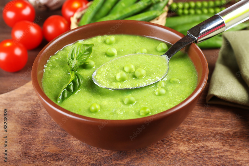 Tasty peas soup and cherry tomatoes on table close up Tasty peas soup and cherry tomatoes on table close up
