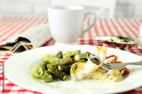 Roasted asparagus with fried egg on plate on table background
