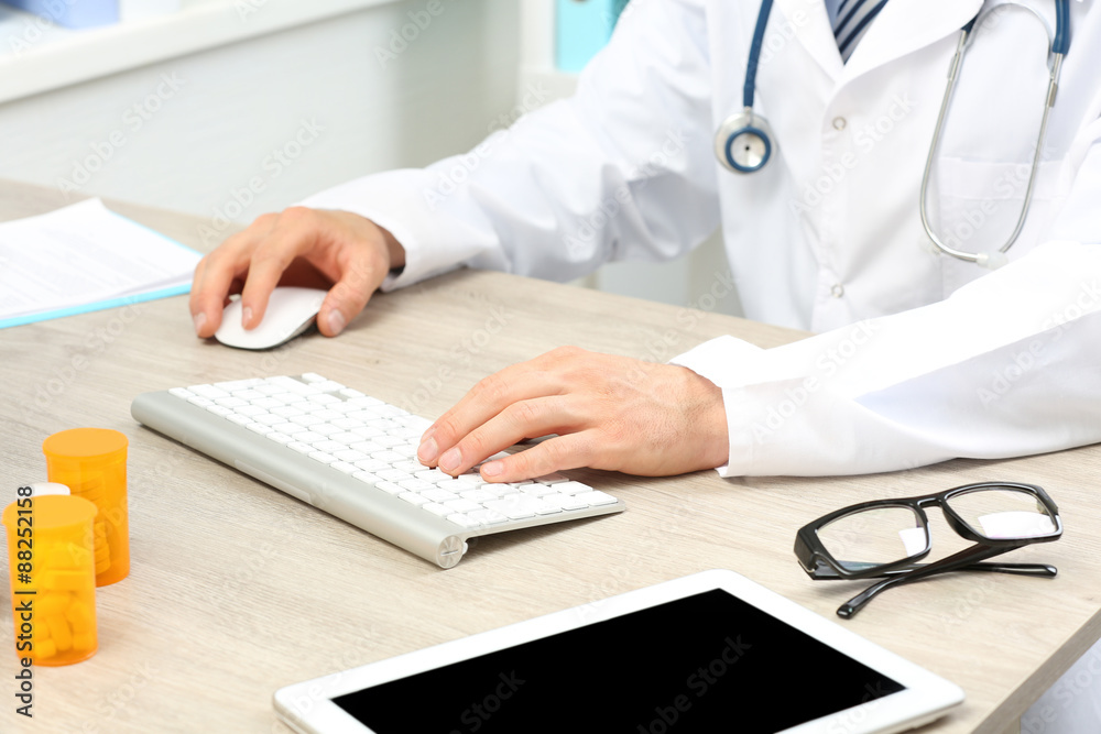 Doctor working at table in office Doctor working at table in office