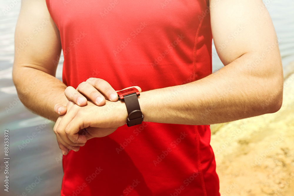 Runner looking at sports smart watch outdoors