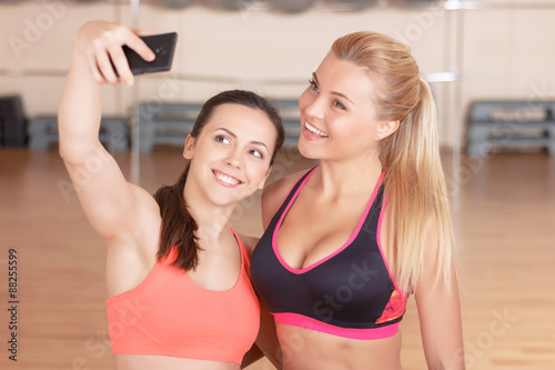 Pair of girls doing selfie in gym 