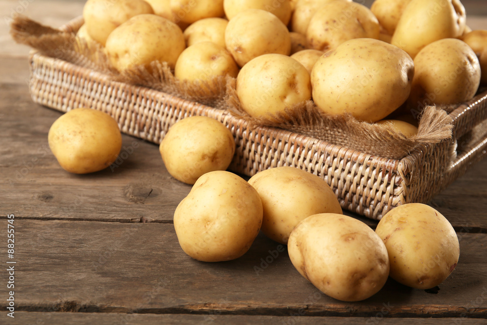 New potatoes in tray on wooden table, closeup New potatoes in tray on wooden table, closeup