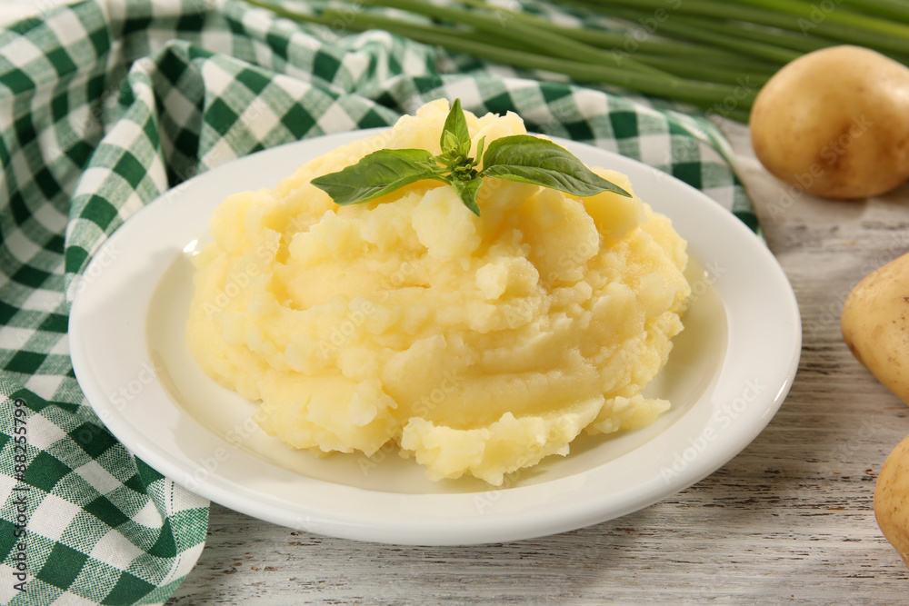 Mashed potatoes in plate on wooden table with checkered napkin, closeup Mashed potatoes in plate on wooden table with checkered napkin, closeup