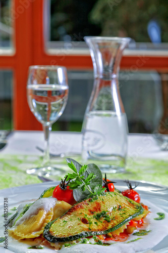 Ravioli mit Grillgem  se auf Tr  ffel  lschaum mit Tomaten angerichtet Nahaufnahme