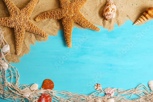 Sand and seashells with sand on wooden background