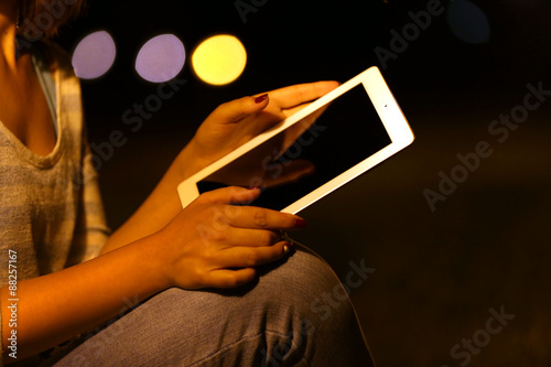 Woman using tablet at night