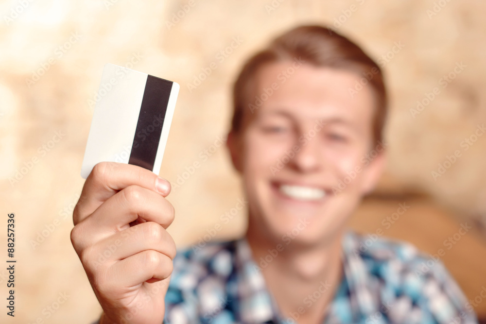 Smiling man showing his credit card 