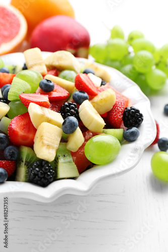 Fresh fruit salad on white wooden table