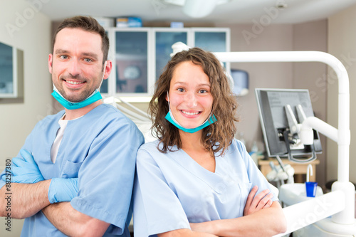 Portrait of a young attractive dentist and his assistant in his photo