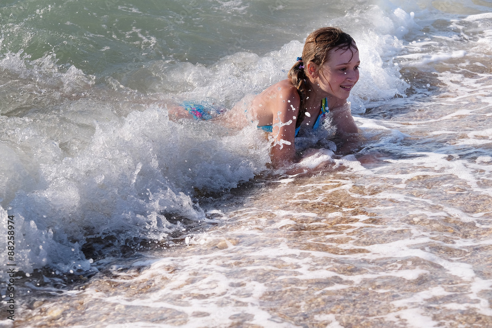 Fototapeta premium Children play in a sea surf