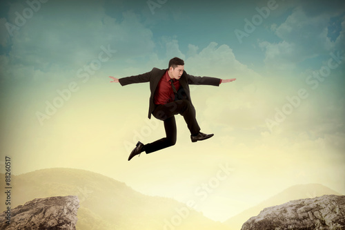 Business woman jump to another peak of mountain