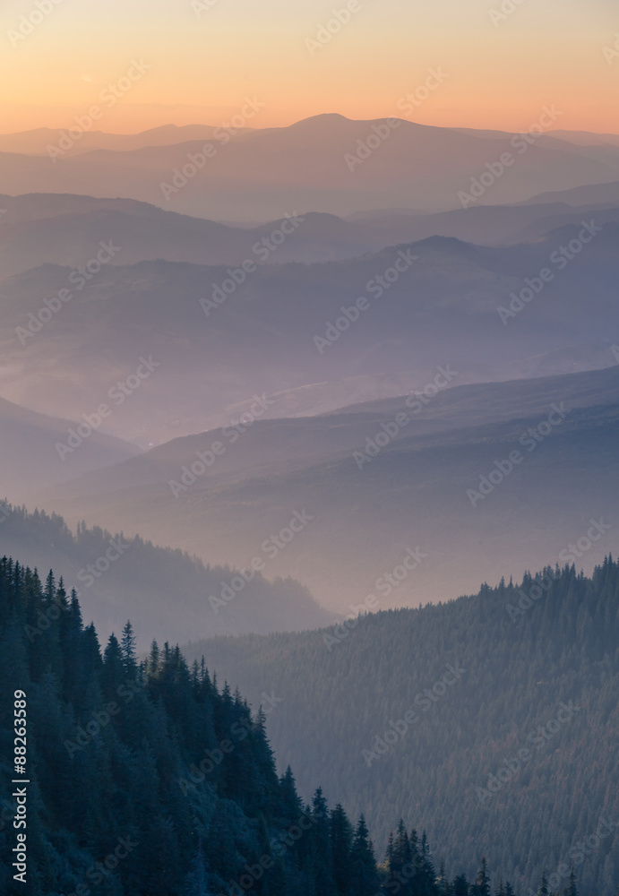 Obraz premium Distant mountain range and thin layer of clouds on the valleys