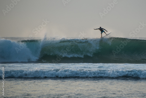 Surfer silhouette riding a wave